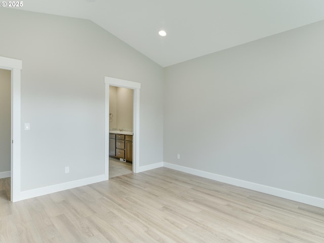 empty room featuring baseboards, light wood finished floors, recessed lighting, and lofted ceiling