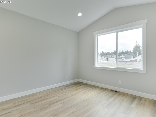 unfurnished room with light hardwood / wood-style floors and vaulted ceiling