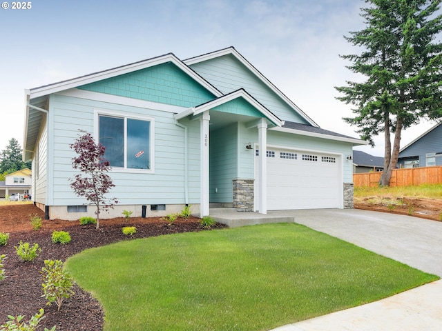 view of front facade featuring concrete driveway, stone siding, a front yard, a garage, and fence