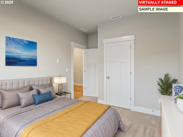 bedroom featuring light wood-type flooring, baseboards, and visible vents