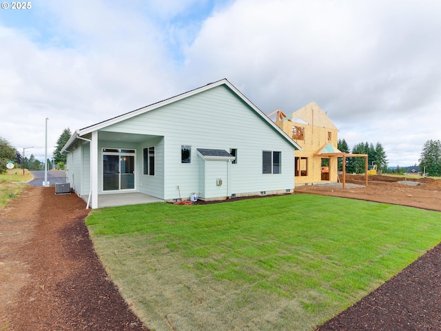 back of house featuring central air condition unit, a yard, and a patio area