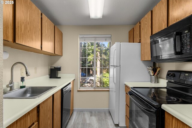 6160 SW Alice Ln Unit 203B, Beaverton, OR 97008 - kitchen featuring black appliances, light wood finished floors, light countertops, and brown cabinets