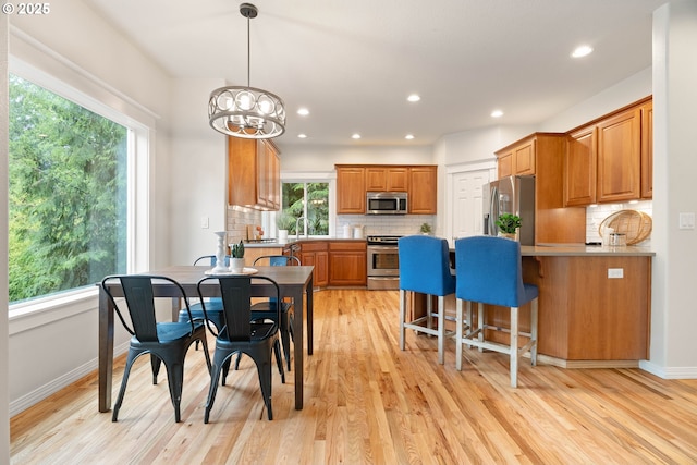 10540 SW Lancaster Rd, Portland, OR 97219 - dining room with light wood finished floors, a chandelier, baseboards, and recessed lighting
