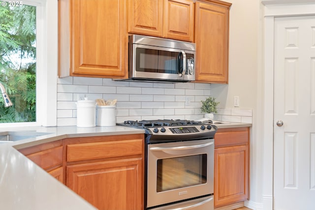 10540 SW Lancaster Rd, Portland, OR 97219 - kitchen with appliances with stainless steel finishes, decorative backsplash, light countertops, and a sink