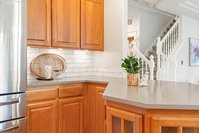 10540 SW Lancaster Rd, Portland, OR 97219 - kitchen with freestanding refrigerator, tasteful backsplash, light countertops, and brown cabinetry