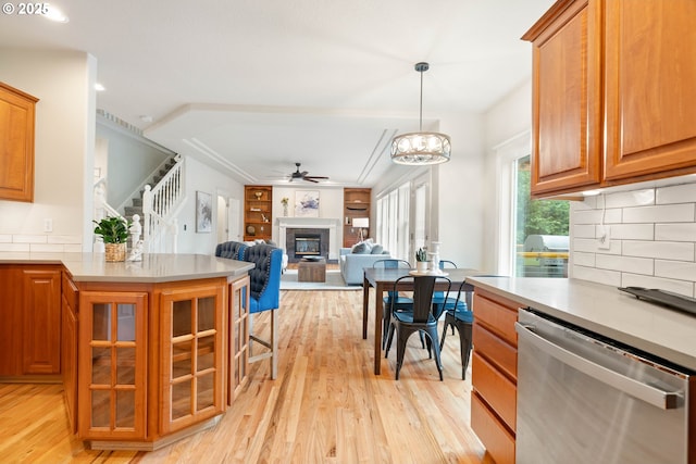 10540 SW Lancaster Rd, Portland, OR 97219 - kitchen with dishwasher, light wood-style floors, a glass covered fireplace, and ceiling fan