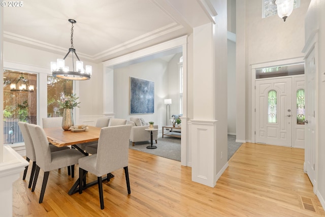 10540 SW Lancaster Rd, Portland, OR 97219 - dining room featuring a chandelier, plenty of natural light, light wood-style flooring, and a decorative wall