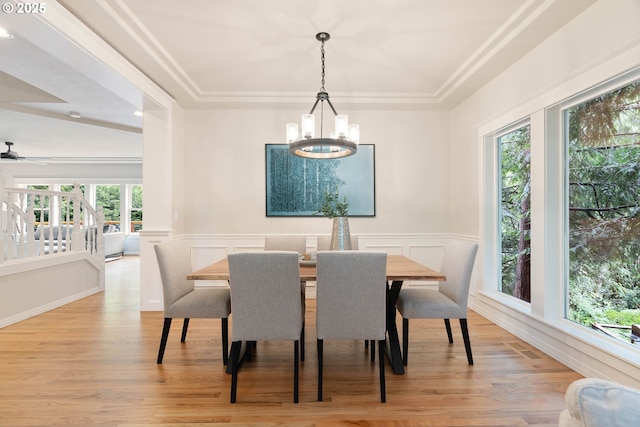 10540 SW Lancaster Rd, Portland, OR 97219 - dining space featuring light wood-style floors, a chandelier, wainscoting, a decorative wall, and ceiling fan