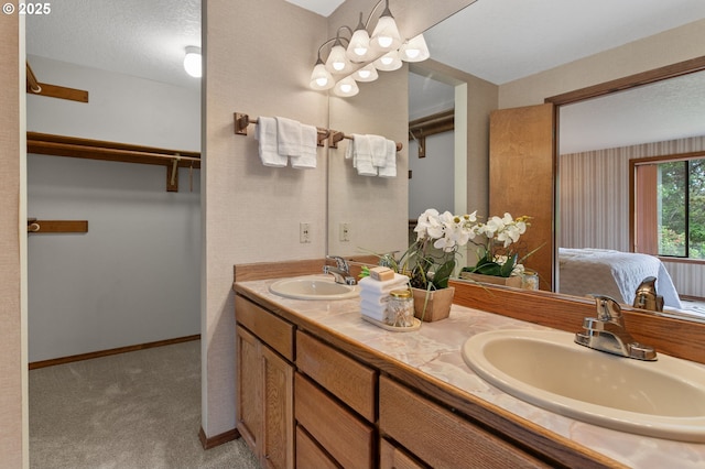 10315 SW 28th Ave, Portland, OR 97219 - bathroom with double vanity, a walk in closet, and baseboards