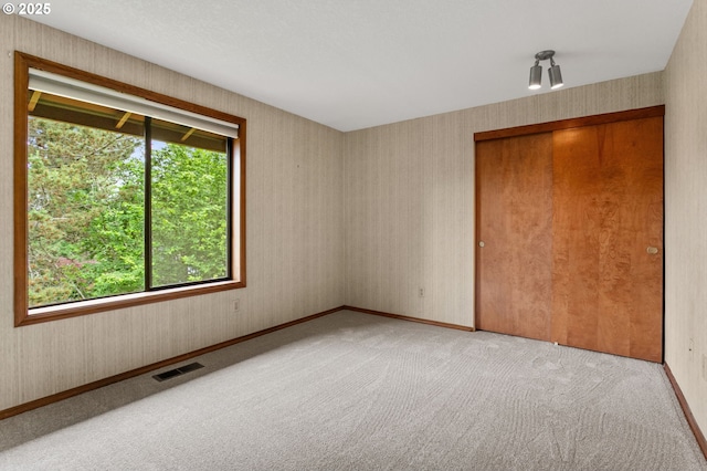 10315 SW 28th Ave, Portland, OR 97219 - unfurnished bedroom featuring multiple windows, light colored carpet, a closet, baseboards, and wallpapered walls
