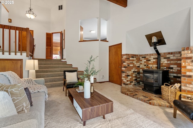 10315 SW 28th Ave, Portland, OR 97219 - carpeted living room featuring stairway, high vaulted ceiling, a wood stove, and baseboards