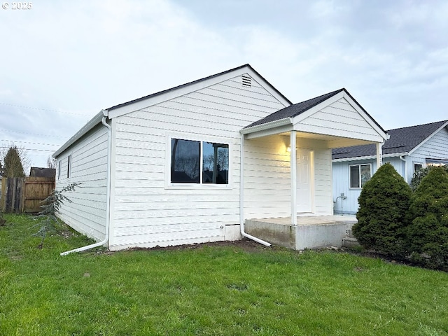 back of house featuring a lawn, a patio, and fence