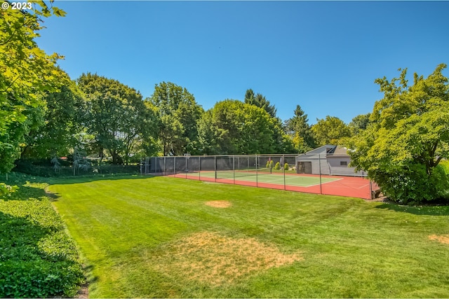 view of sport court with a lawn