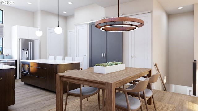 dining space with light wood finished floors and recessed lighting