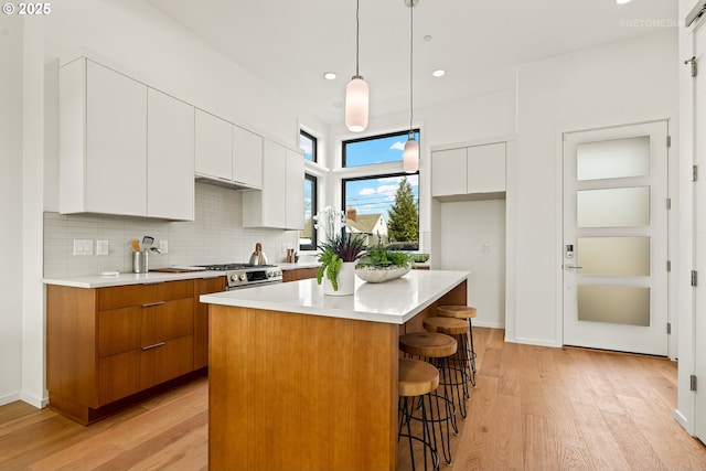 2417 E 6th St, Vancouver, WA 98661 - kitchen with stainless steel range with gas cooktop, modern cabinets, a breakfast bar, a center island, and light wood finished floors