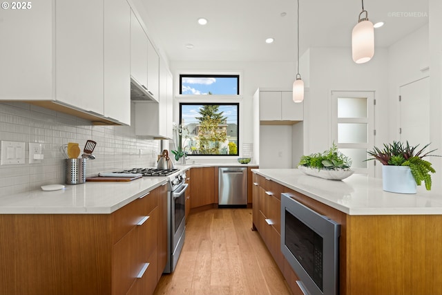 2417 E 6th St, Vancouver, WA 98661 - kitchen with modern cabinets, white cabinetry, stainless steel appliances, brown cabinets, and backsplash