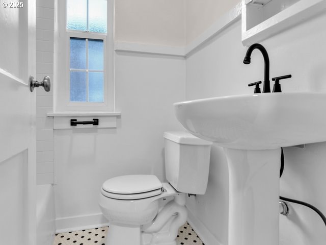 bathroom featuring a shower, baseboards, and toilet