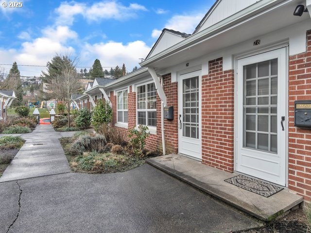 entrance to property with board and batten siding and brick siding