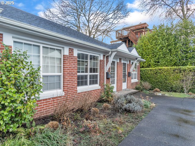 view of property exterior featuring brick siding and roof with shingles