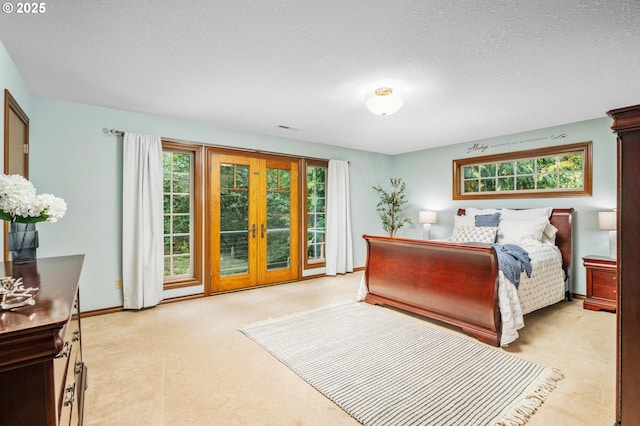 bedroom with light carpet, a textured ceiling, french doors, baseboards, and visible vents