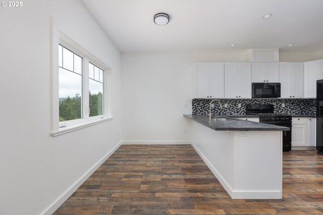 kitchen with white cabinetry, decorative backsplash, black appliances, and kitchen peninsula