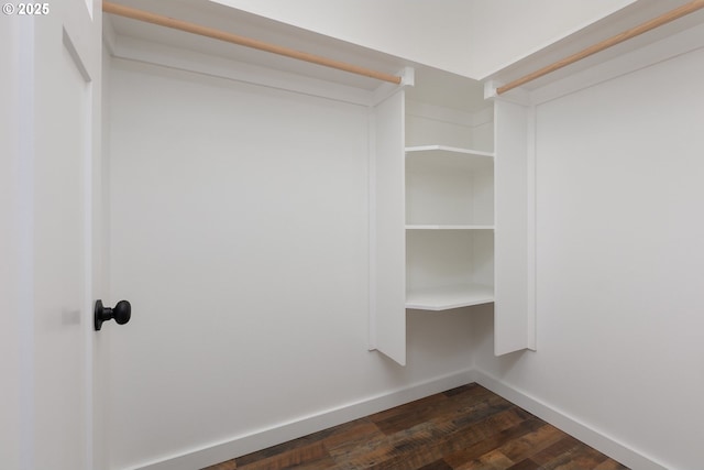 walk in closet with dark hardwood / wood-style floors