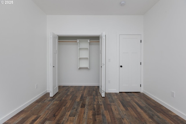 unfurnished bedroom with dark wood-type flooring and a closet