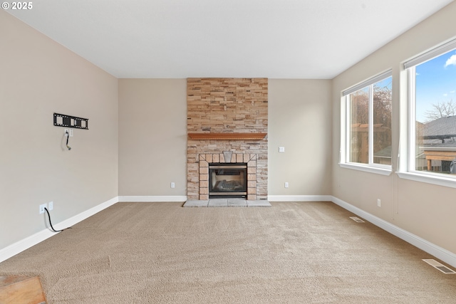 unfurnished living room with light carpet and a fireplace