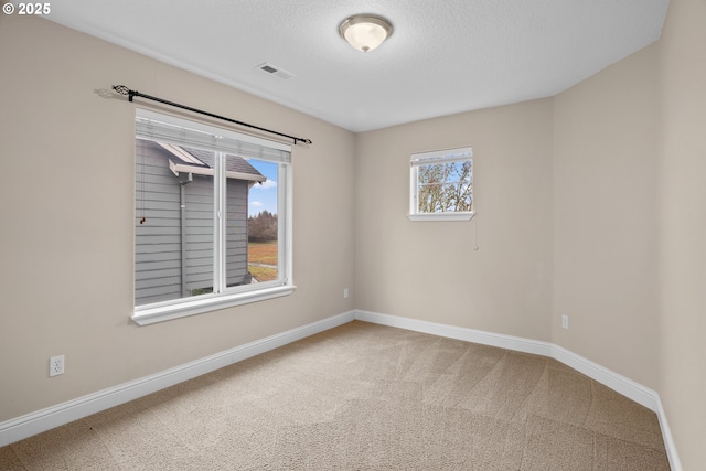 empty room with a textured ceiling and carpet floors