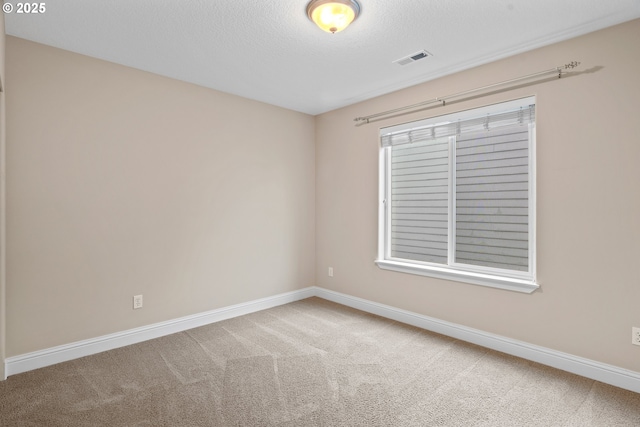 carpeted empty room with a textured ceiling