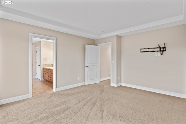 unfurnished bedroom with connected bathroom and light colored carpet