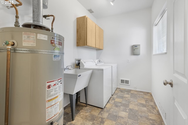 2689 Cupola Dr, Eugene, OR 97403 - washroom with strapped water heater, cabinet space, washing machine and clothes dryer, and stone finish flooring