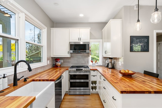 17 S Curry St, Portland, OR 97239 - kitchen with wood counters, appliances with stainless steel finishes, a sink, tasteful backsplash, and recessed lighting