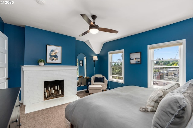 17 S Curry St, Portland, OR 97239 - carpeted bedroom featuring a brick fireplace, vaulted ceiling, multiple windows, and ceiling fan