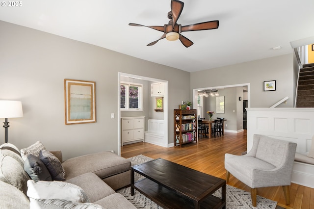 17 S Curry St, Portland, OR 97239 - living room featuring a ceiling fan, stairs, wood finished floors, and a chandelier