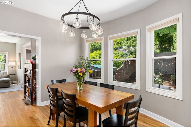 17 S Curry St, Portland, OR 97239 - dining room with light wood-type flooring, baseboards, and a chandelier