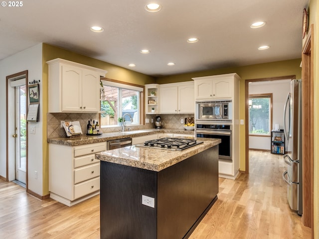 29643 SW Young Way, Wilsonville, OR 97070 - kitchen with stainless steel appliances, recessed lighting, light wood-style floors, white cabinetry, and decorative backsplash