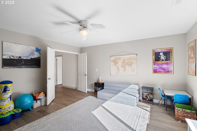 bedroom with a ceiling fan, baseboards, and wood finished floors