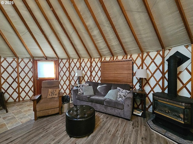 living area with a wood stove and wood finished floors