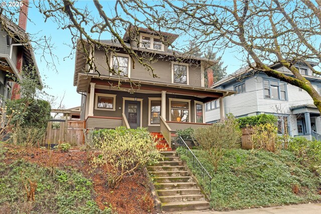 american foursquare style home featuring stairs, fence, and covered porch