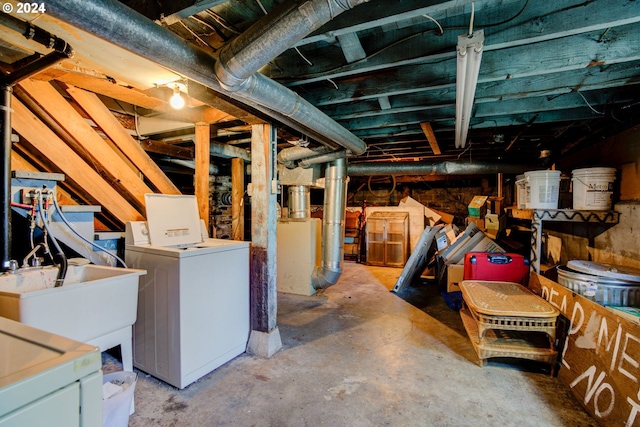unfinished basement featuring washing machine and clothes dryer and a sink