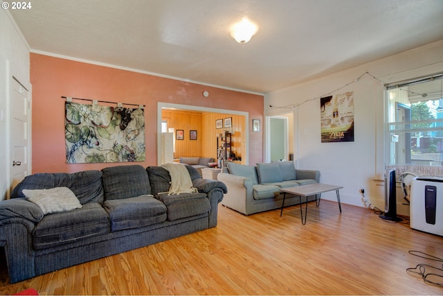 living area featuring wood finished floors and crown molding