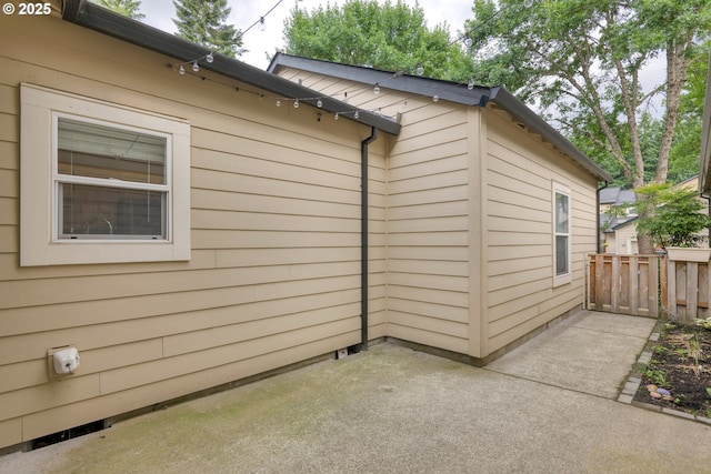 view of side of property with a patio and fence