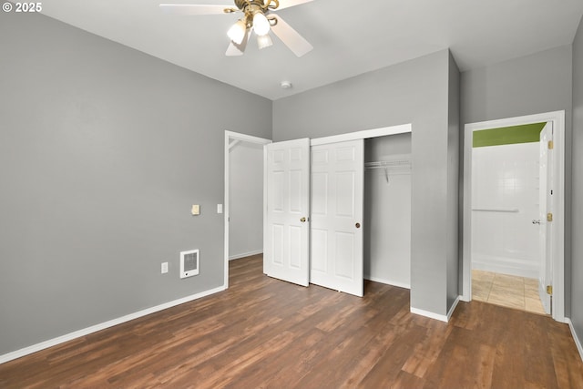unfurnished bedroom with wood finished floors, a closet, baseboards, and ceiling fan
