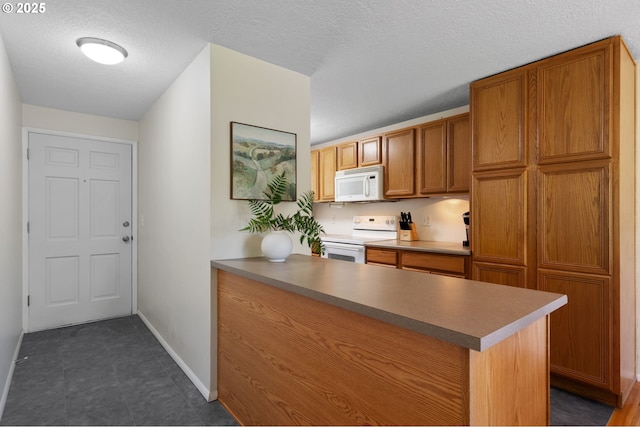 18344 Terry Ave, Lake Oswego, OR 97035 - kitchen with white appliances, brown cabinets, a textured ceiling, baseboards, and a peninsula