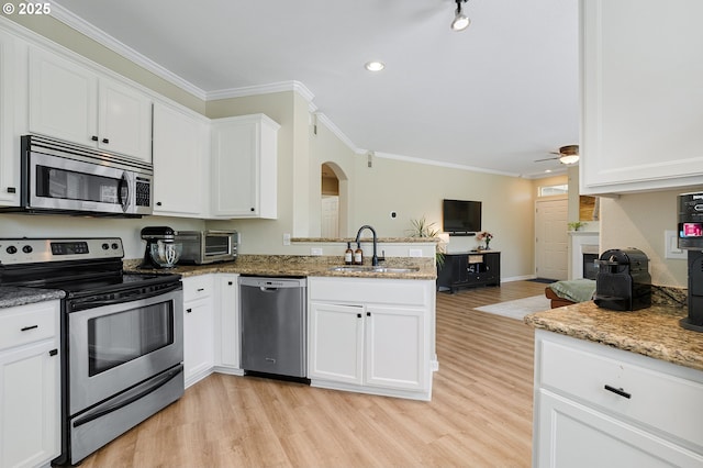 595 Springtree Ln, West Linn, OR 97068 - kitchen with appliances with stainless steel finishes, a sink, arched walkways, crown molding, and light wood-type flooring