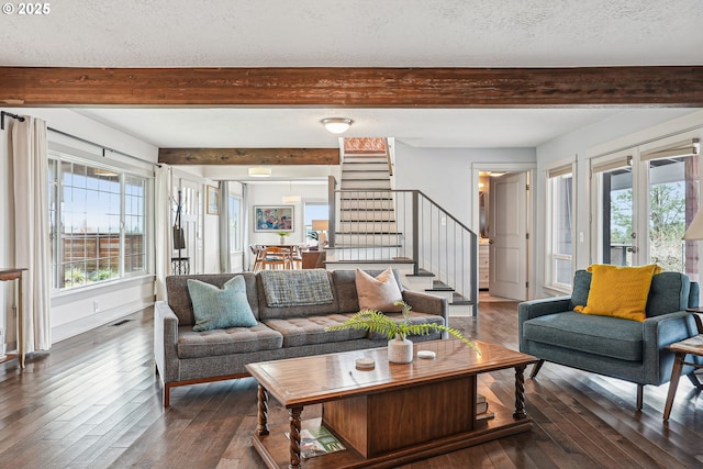 living area with a healthy amount of sunlight, hardwood / wood-style floors, stairs, and beam ceiling