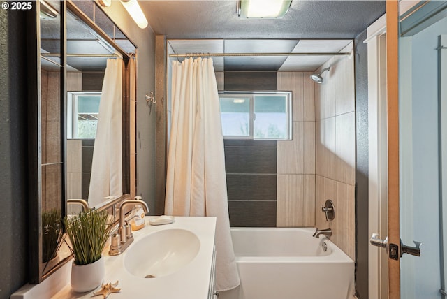 full bathroom featuring shower / tub combo, vanity, and a textured ceiling