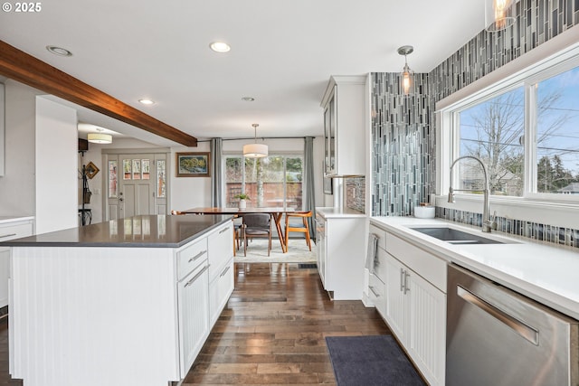 kitchen with dark wood-type flooring, stainless steel dishwasher, pendant lighting, a sink, and recessed lighting