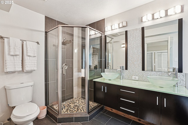 full bath featuring a stall shower, double vanity, a sink, and tile patterned floors